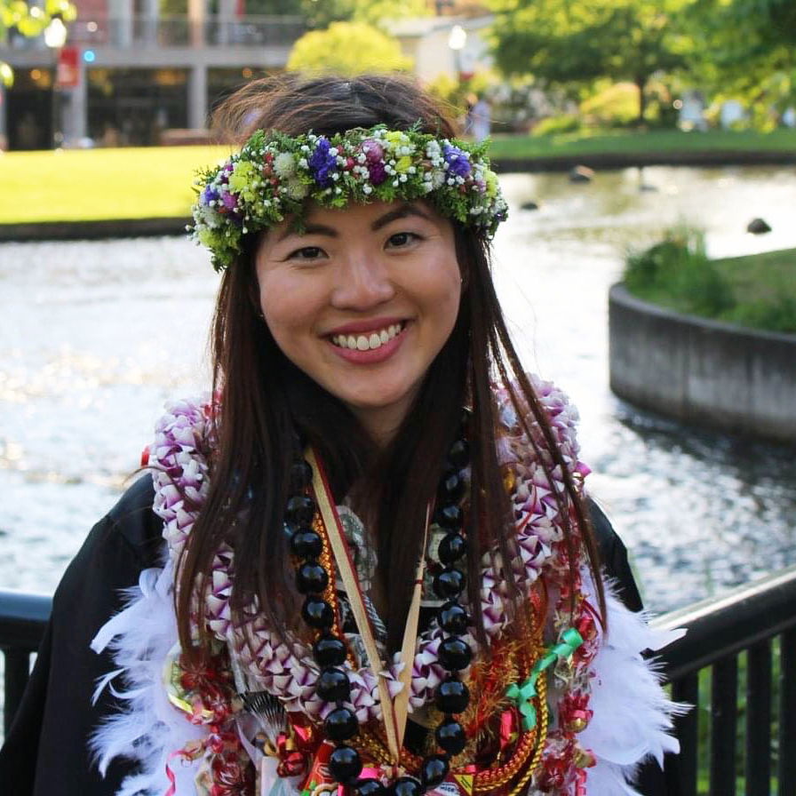 Ariel Todoki standing in front of the Willamette Salem's campus Millstream with leis