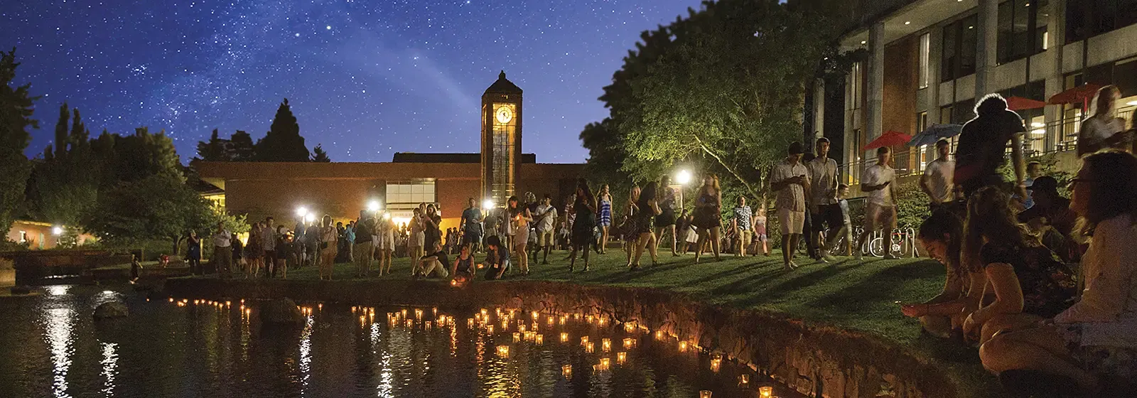 Matriculation ceremony during Opening Days at Willamette University. Students float candles down the Mill Stream on a starry evening.