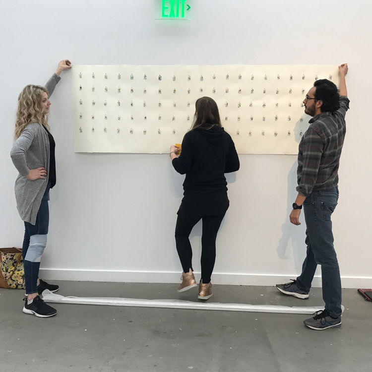 PNCA students hang an art project in a gallery space