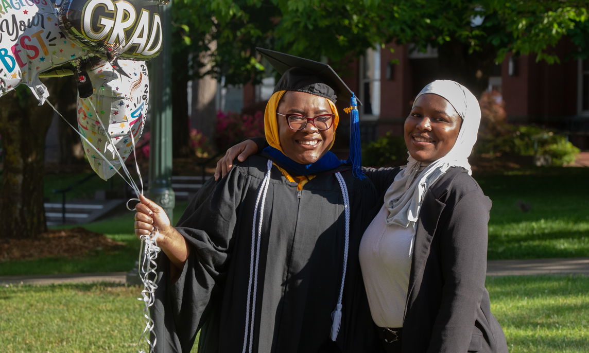 Two MBA students at graduation. 