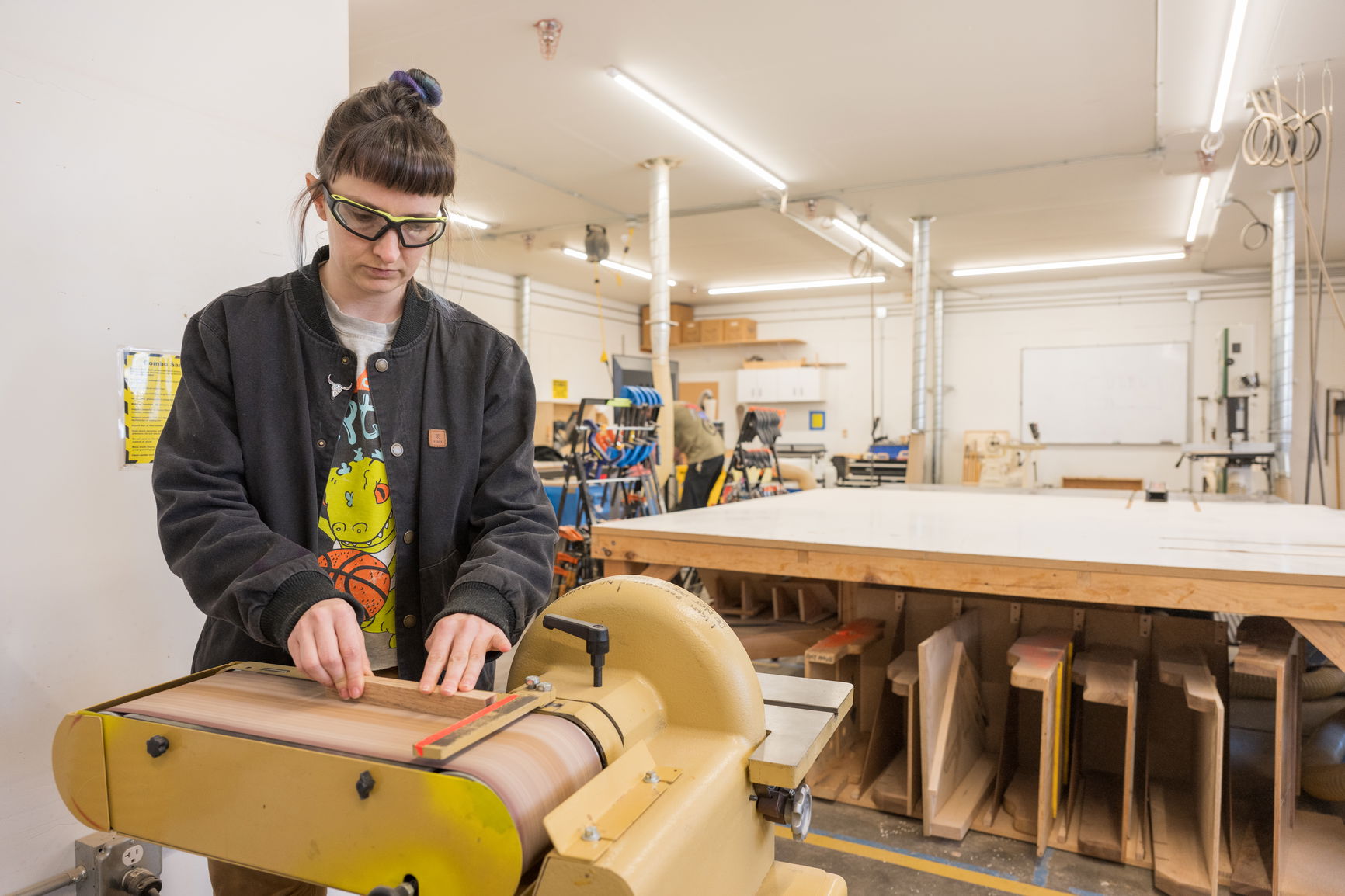 A person working on a machine with protective glasses