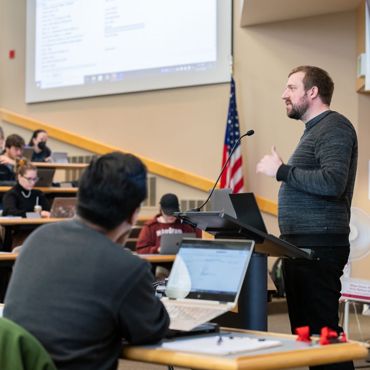 A professor speaking to a large classroom of students