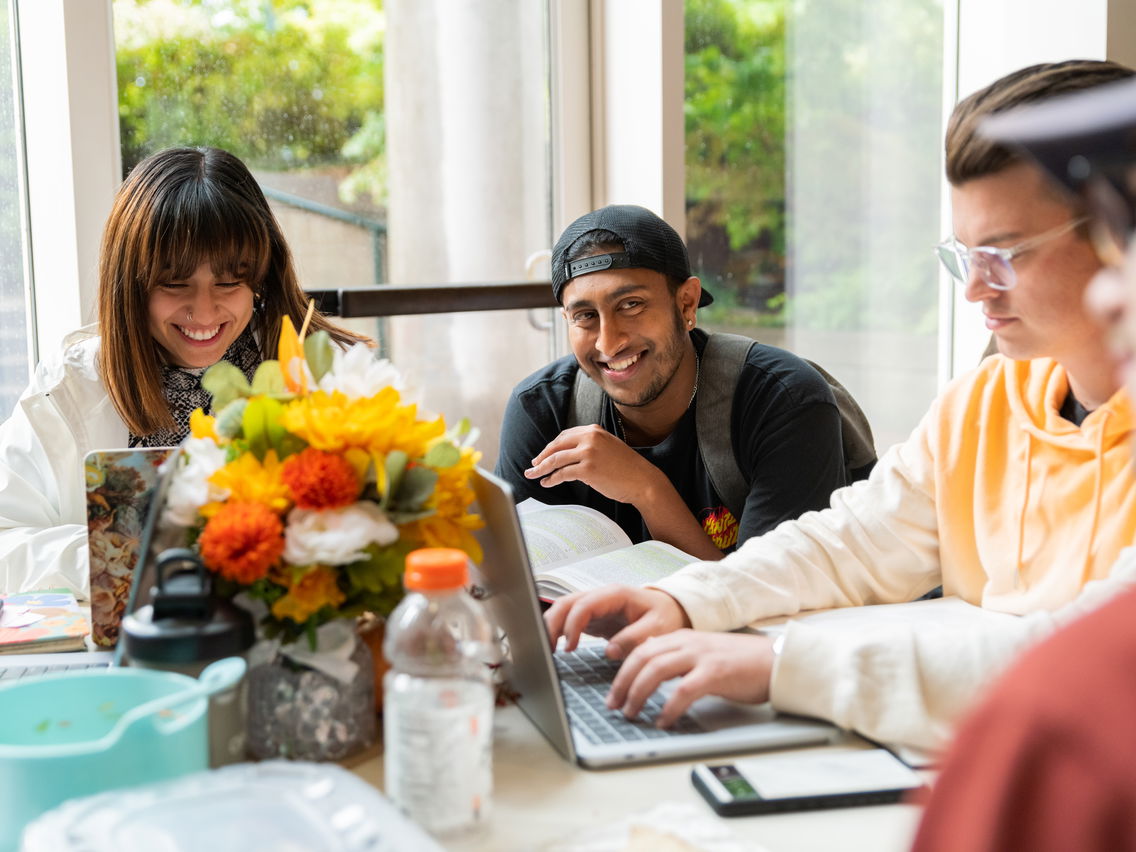 Students chatting around a table with flowers