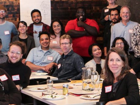 A group of people smiling in a room with nametags