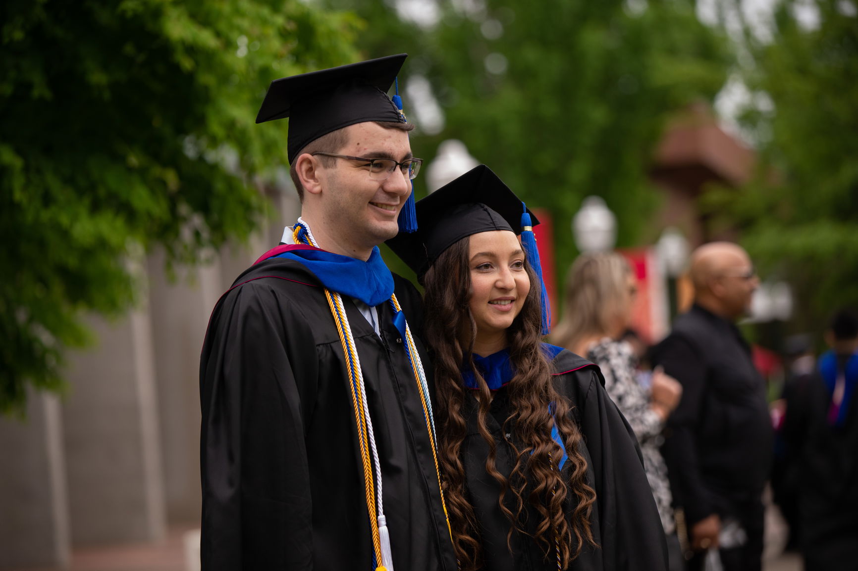 Two MBA students at Commencement wearing cap and gowns. 