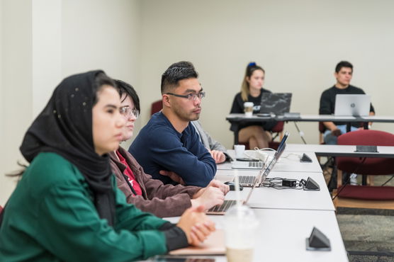 Three Willamette MBA students sit in a classroom