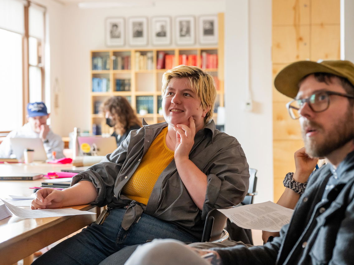 Students sitting at a table paying attention to a lecture.