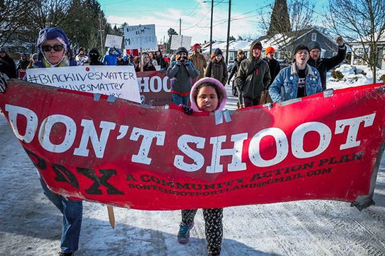 People holding up a Don't Shoot PDX sign