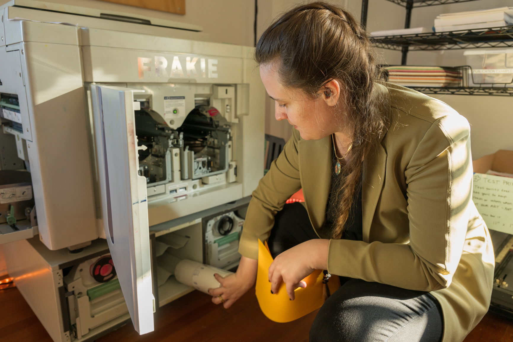 A person putting something way near a machine labeled Frankie