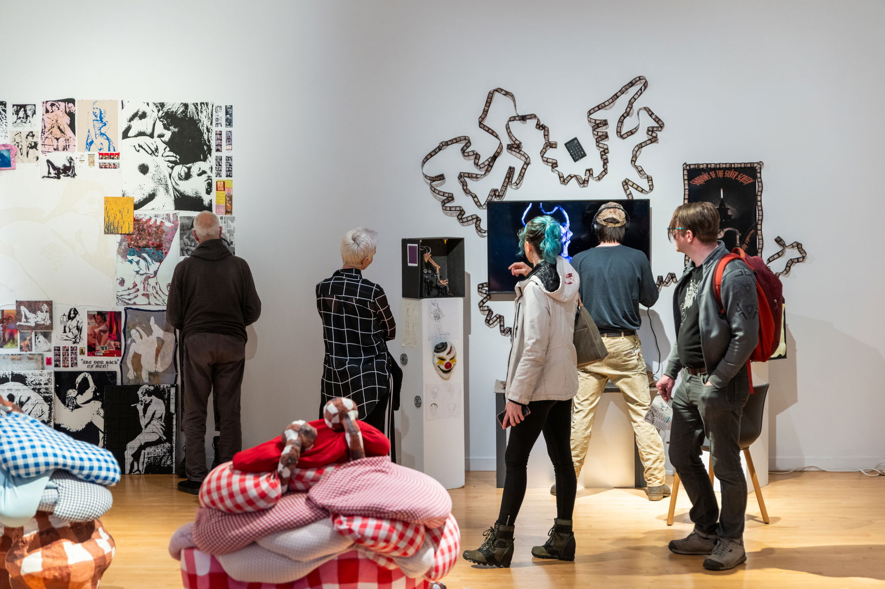 People standing around in a white gallery room