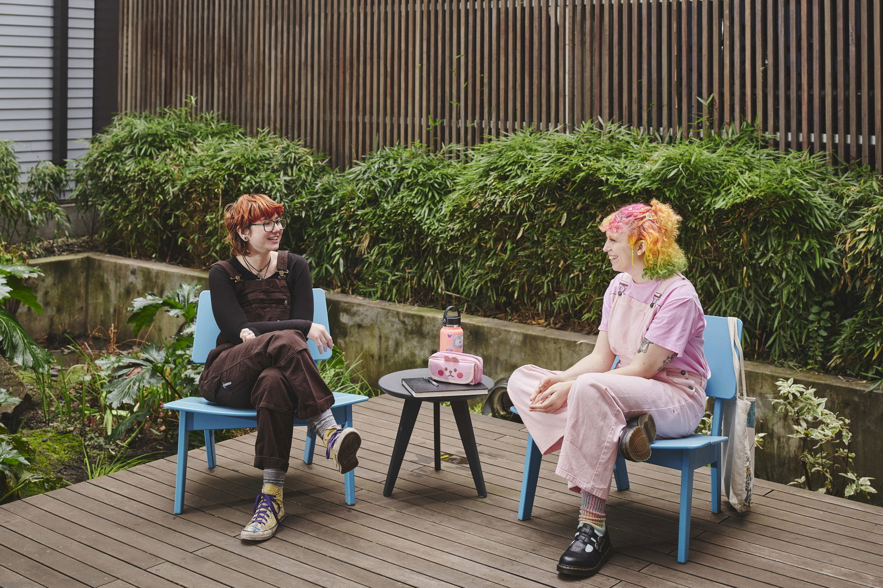 Two students sit in the courtyard at ArtHouse