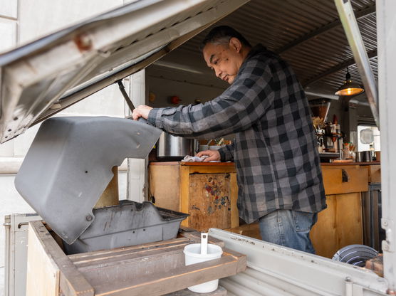 a person cooks on a grill in a food cart