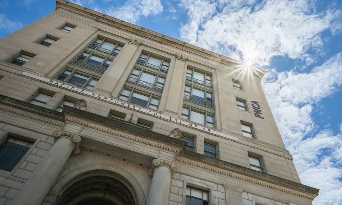 PNCA campus building detail with blue sky and a sun star