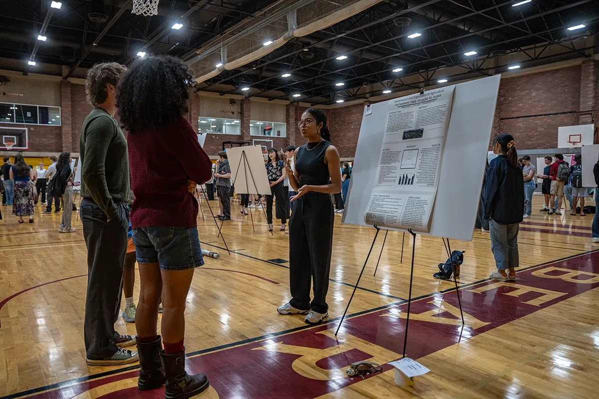 Student Scholarship Recognition Day where a student is discussing a poster with other students