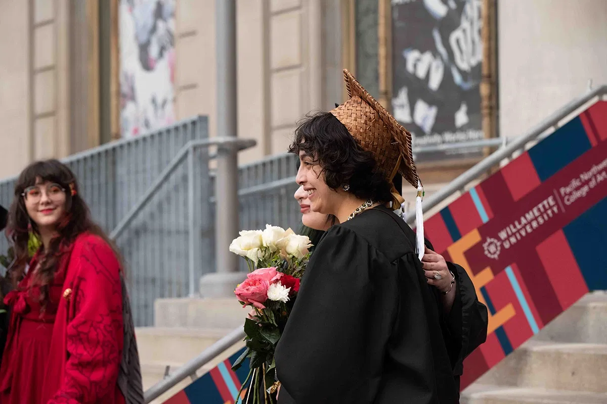 A PNCA student smiling for the camera at graduation