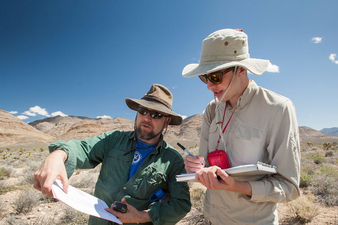 Two people completing research in the desert.