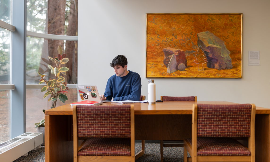 A student sitting in a Willamette library while studying