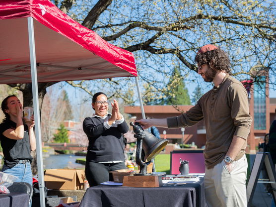 A person ringing a bell at Willamette University