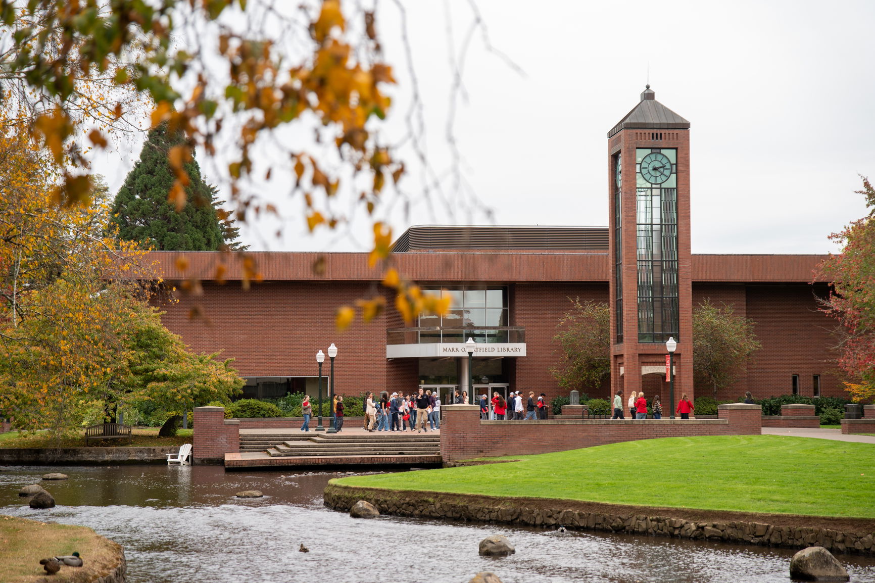 A brick building near a stream and grass on the Willamette campus