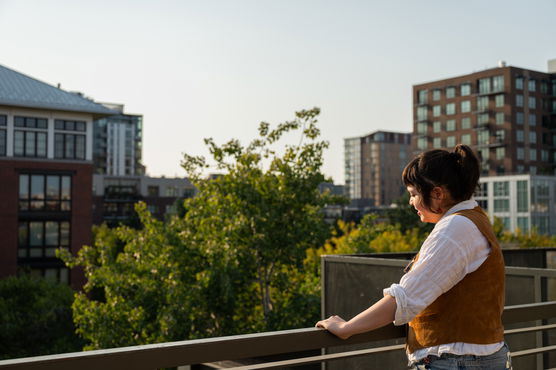 a person stands on a balcony overlooking downtown Portland