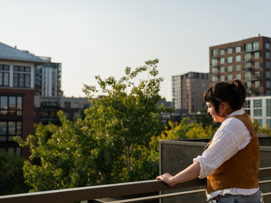 a person stands on a balcony overlooking downtown Portland