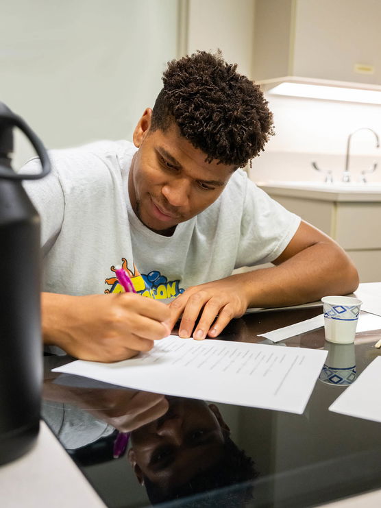 A Willamette University student working on a paper in a classroom