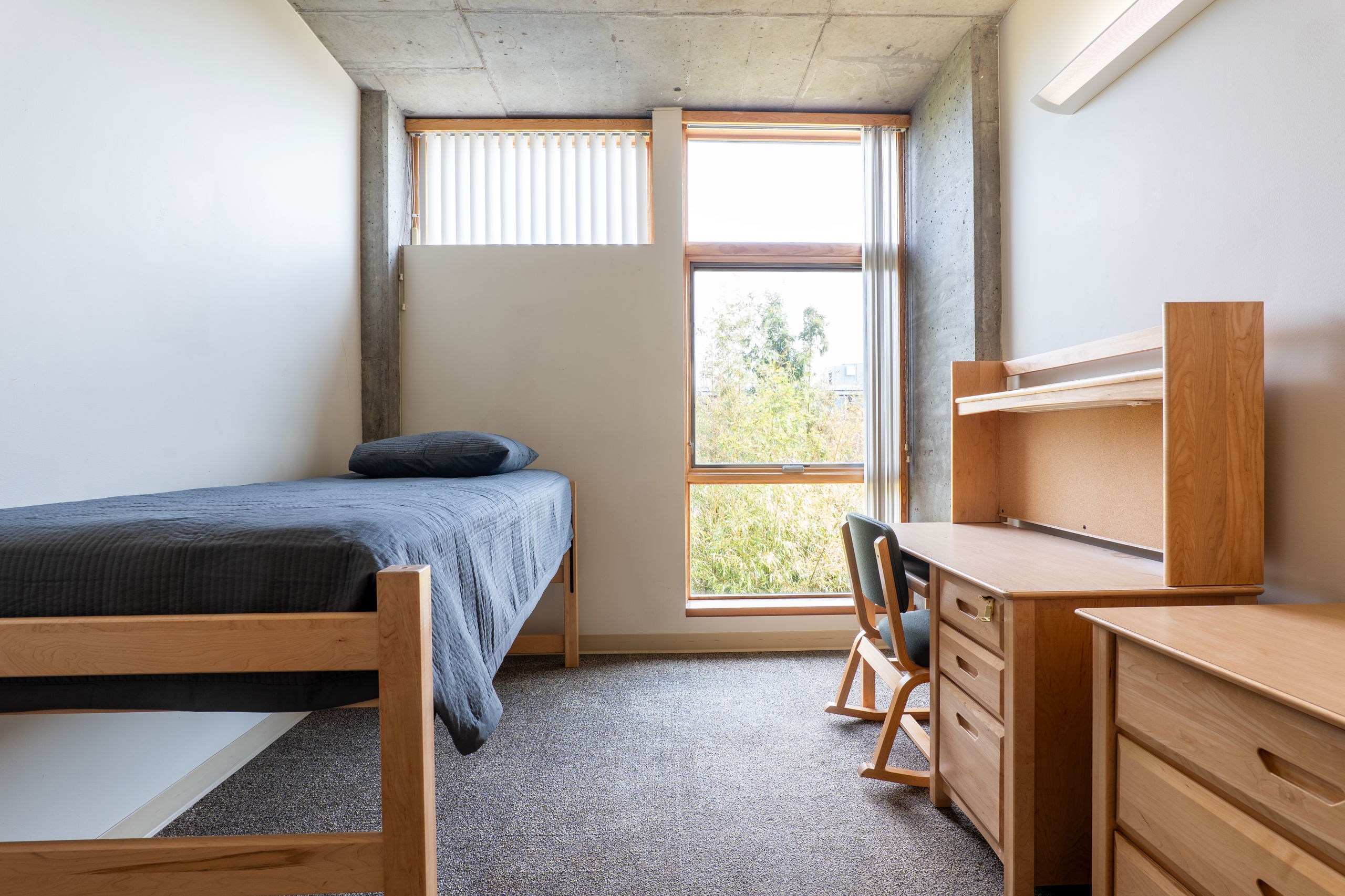 Room in apartment showing a desk, chair, armoire, and bed