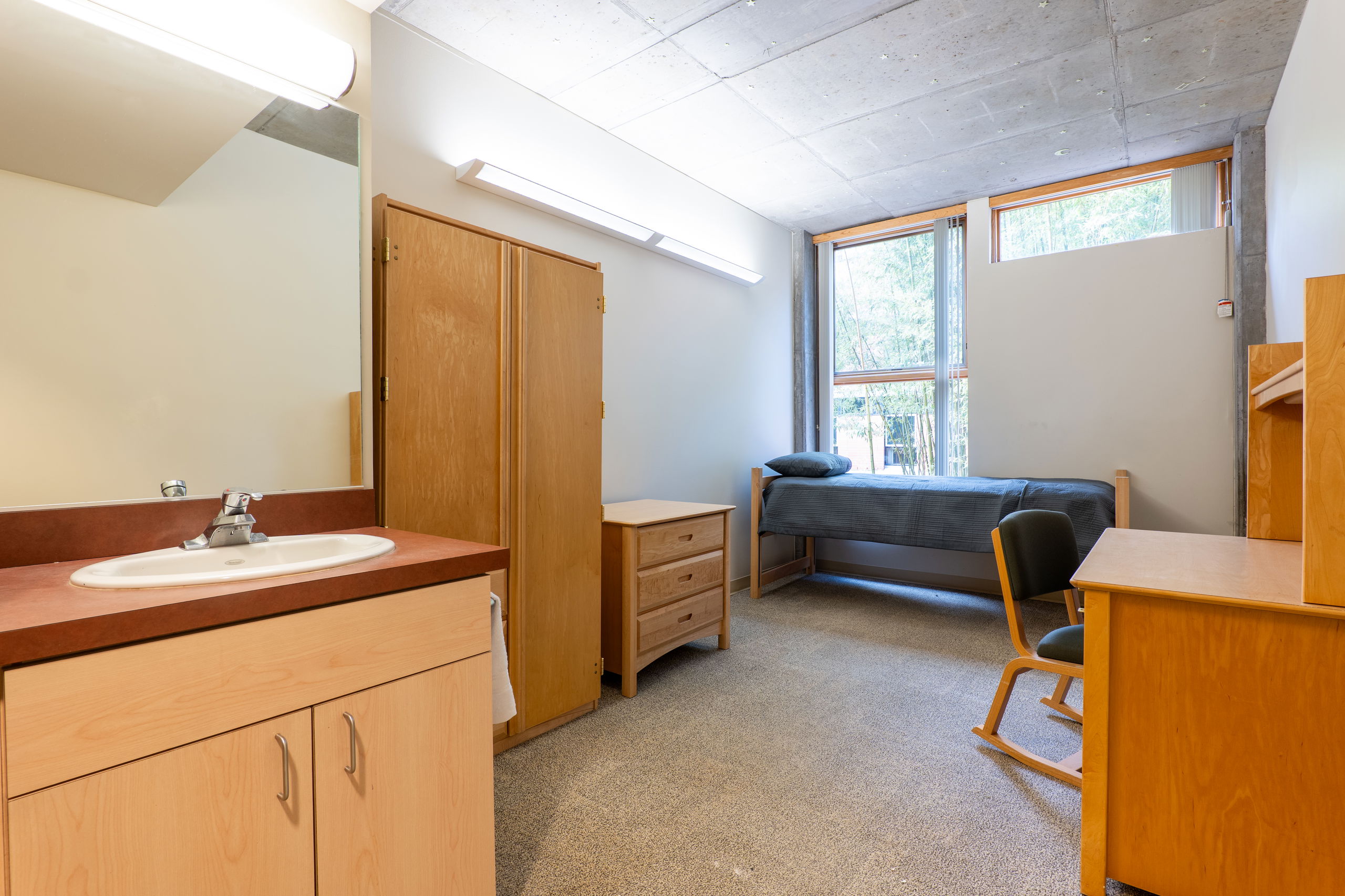 Kaneko single room showing a bed, armoire, desk, chair, sink, and cabinets