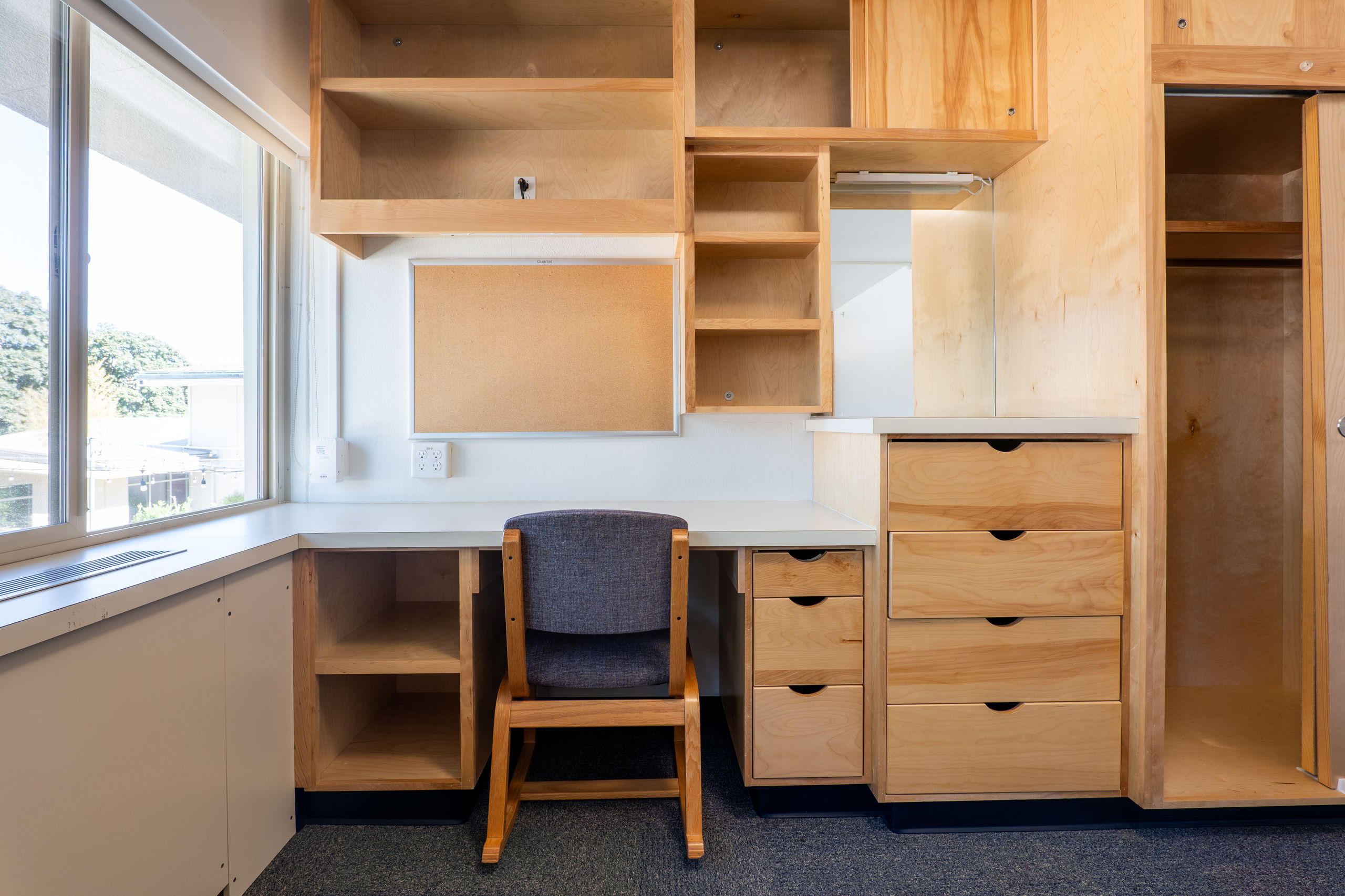 Lee room showing built in desk, storage, closet, and a chair