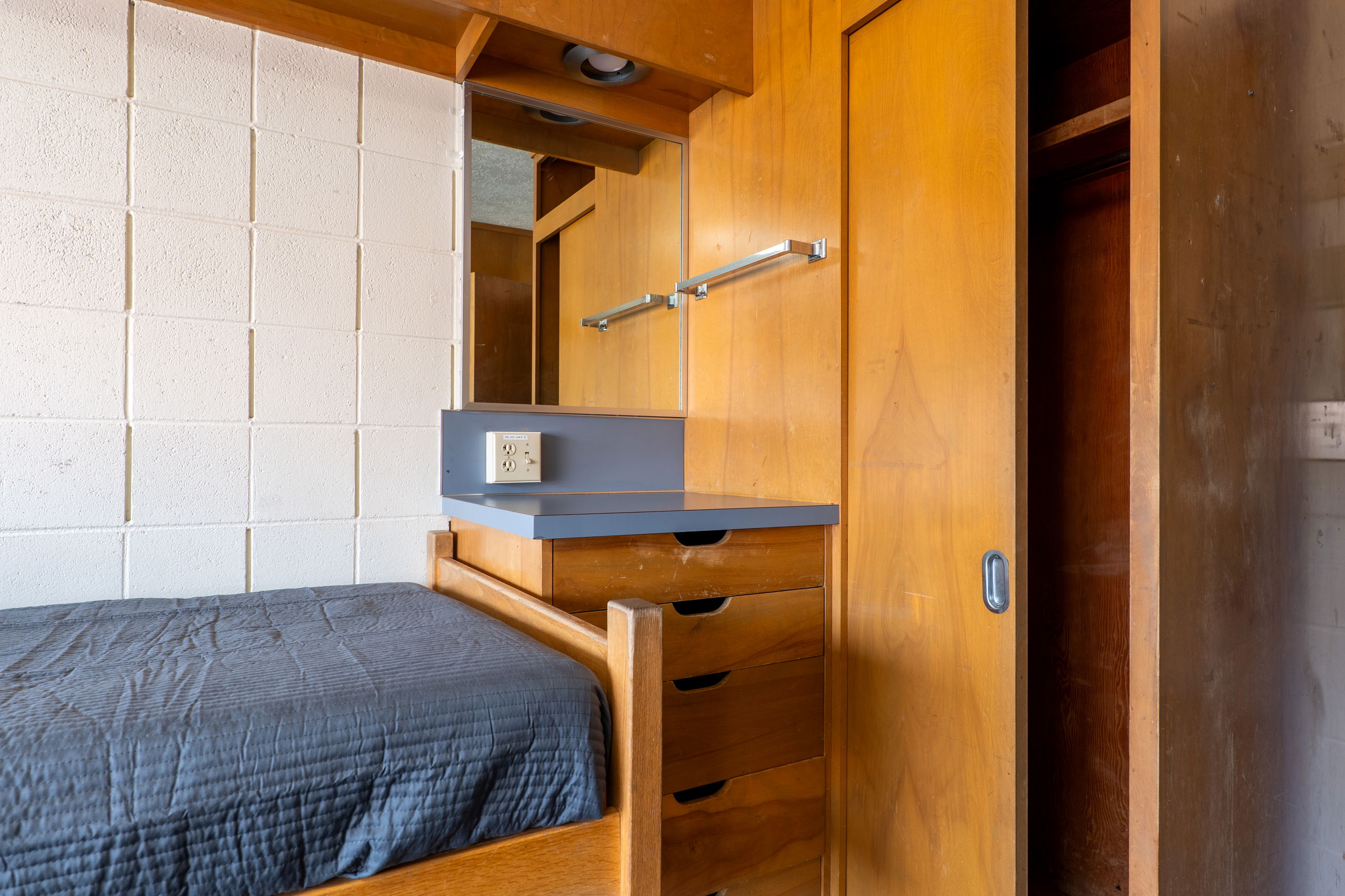 one side of double room showing a sink, cabinet and drawers, a closet, and a bed