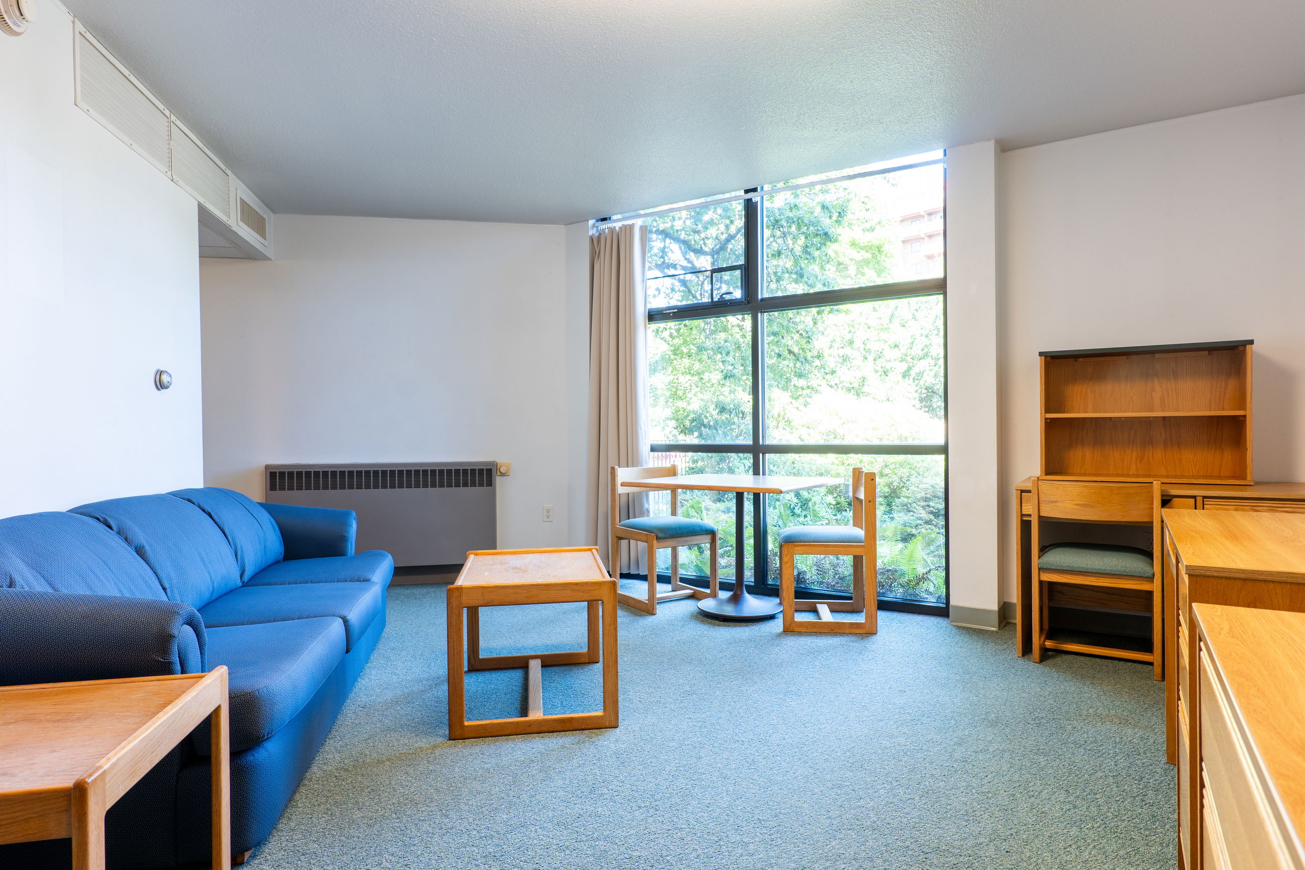 University Apartments living space showing desks, couches, and windows