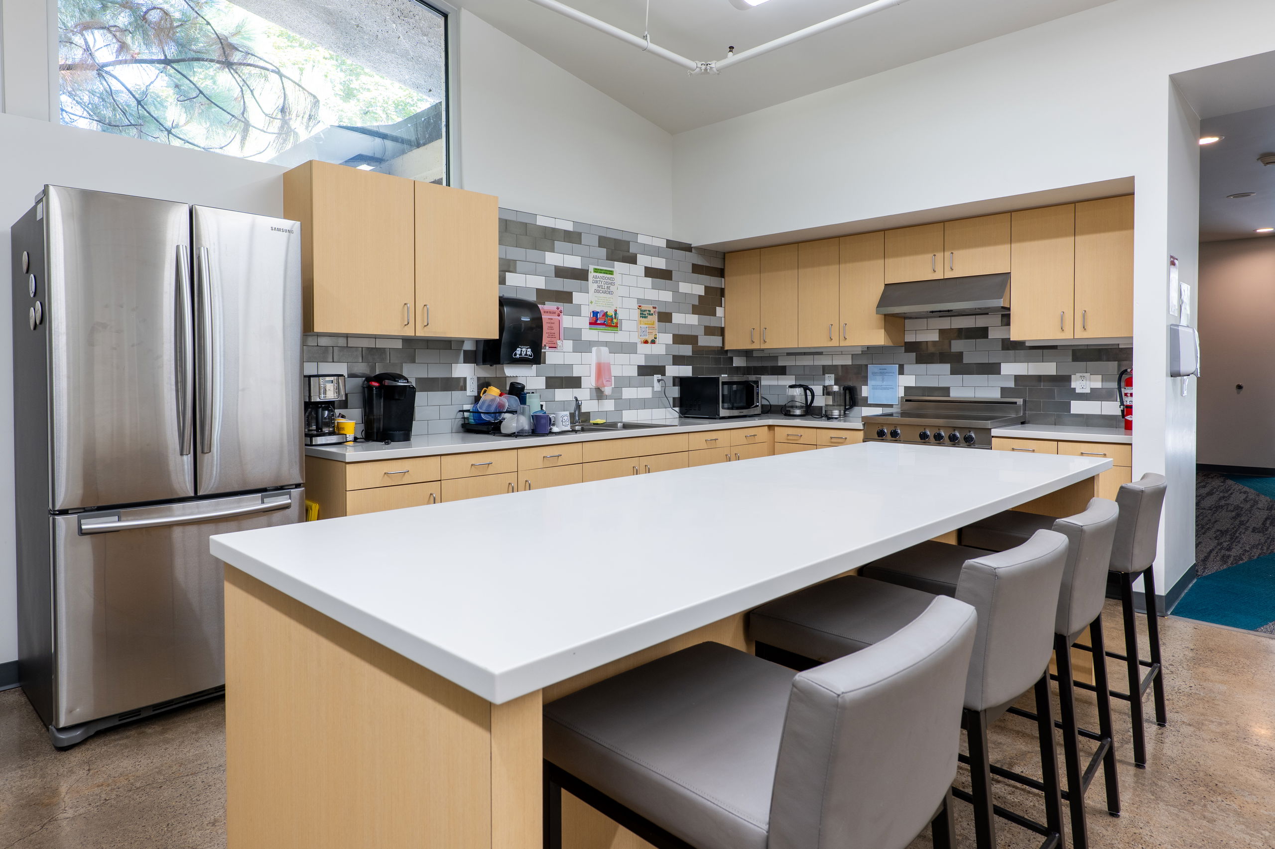 York common area kitchen with a middle island, oven and stove, fridge and freezer, and sink and counter spaces