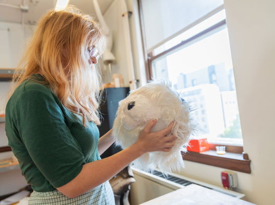 A PNCA undergrad student holds a fuzzy white sculpture in PNCA's 3-D Design classroom