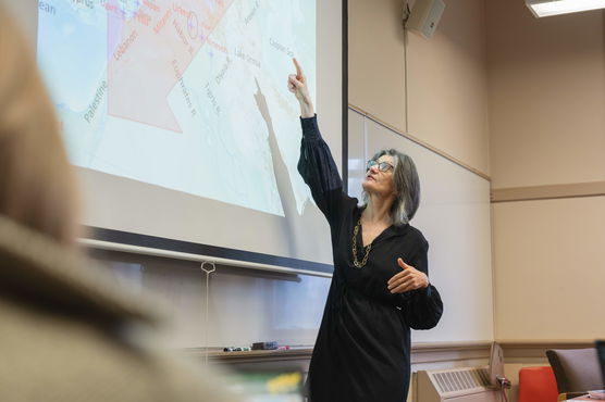 Willamette Classical Studies Professor Mary Bachvarova points at a map of the Mediterranean projected in her classroom