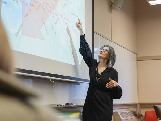 Willamette Classical Studies Professor Mary Bachvarova points at a map of the Mediterranean projected in her classroom