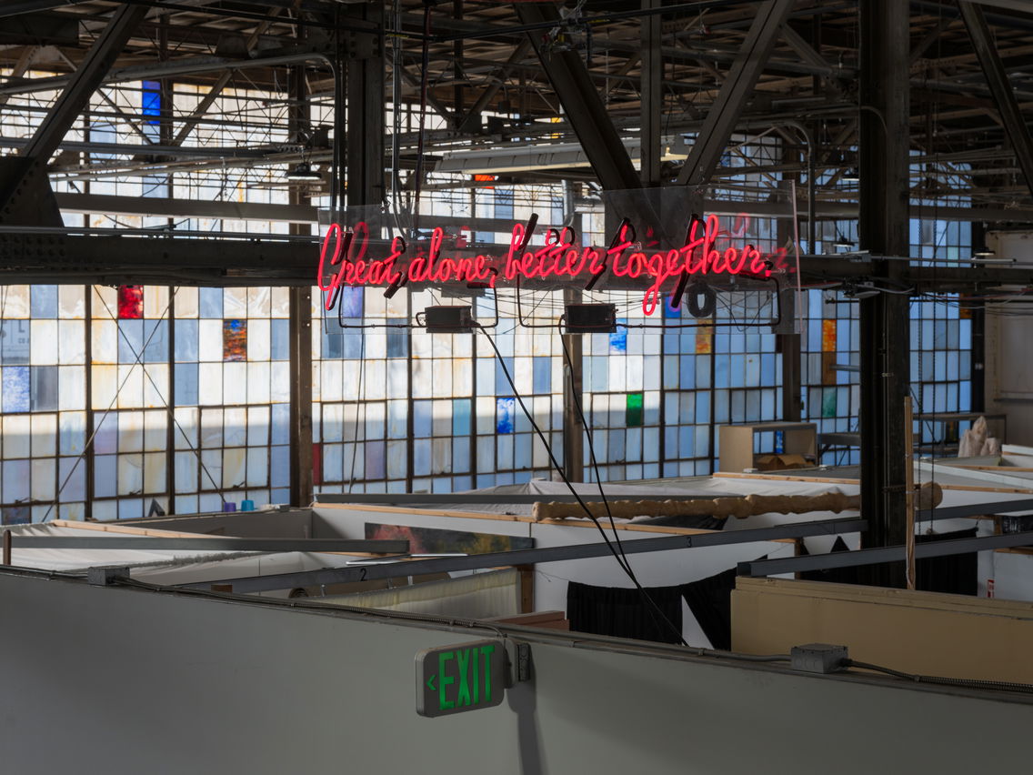 PNCA's Glass Building, an old glass factory with a sign reading "Great alone, better together" suspended from the ceiling