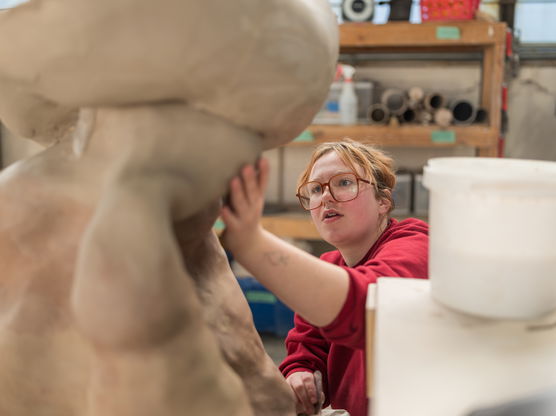 A PNCA student works on a large sculpture in the ceramic studio