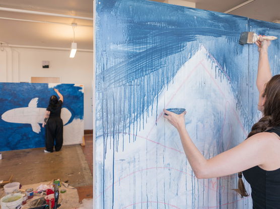 Two PNCA students painting blue murals during a Painting and Drawing studio class