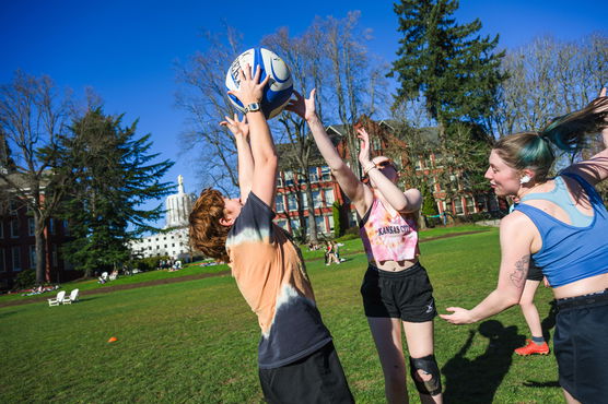 A group of Willamette students playing rugby on the Quad on a sunny day