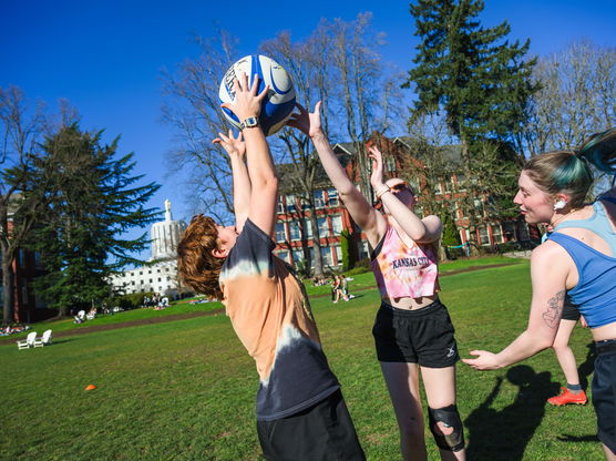 A group of Willamette students playing rugby on the Quad on a sunny day