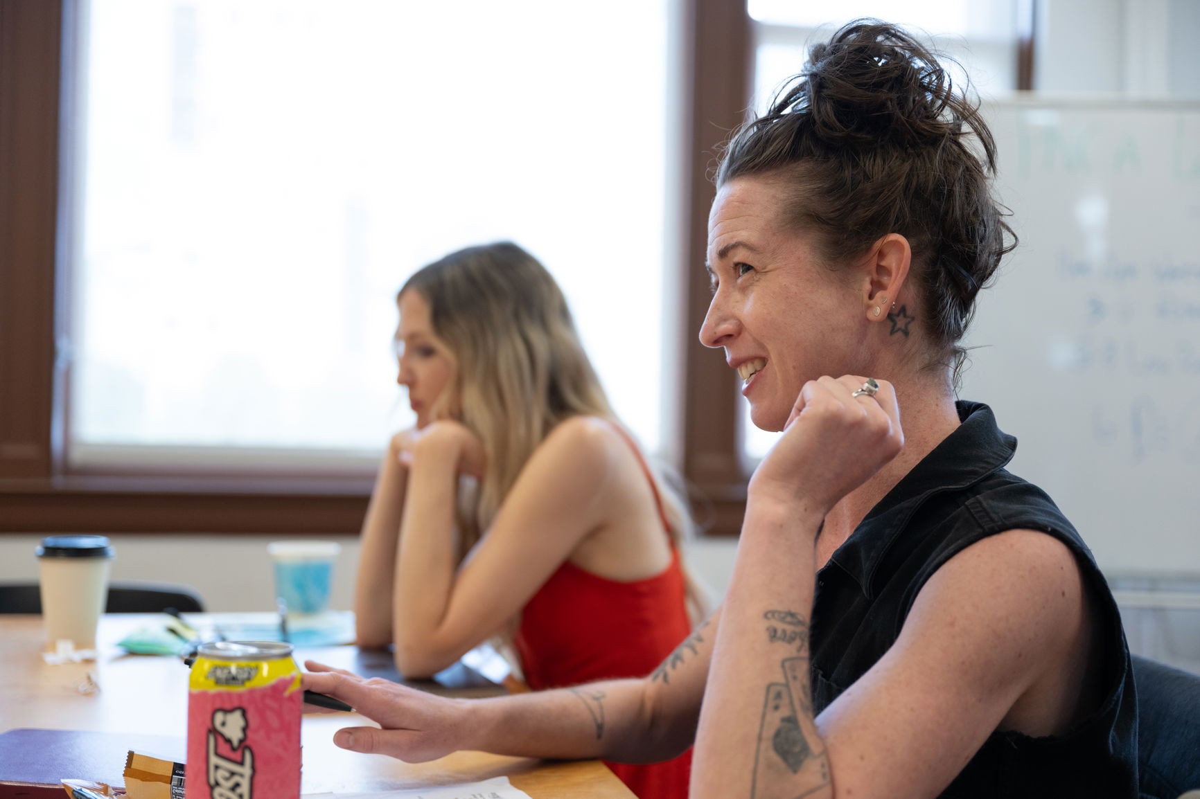 Two PNCA students sitting at a table in a classroom during a creative writing workshop