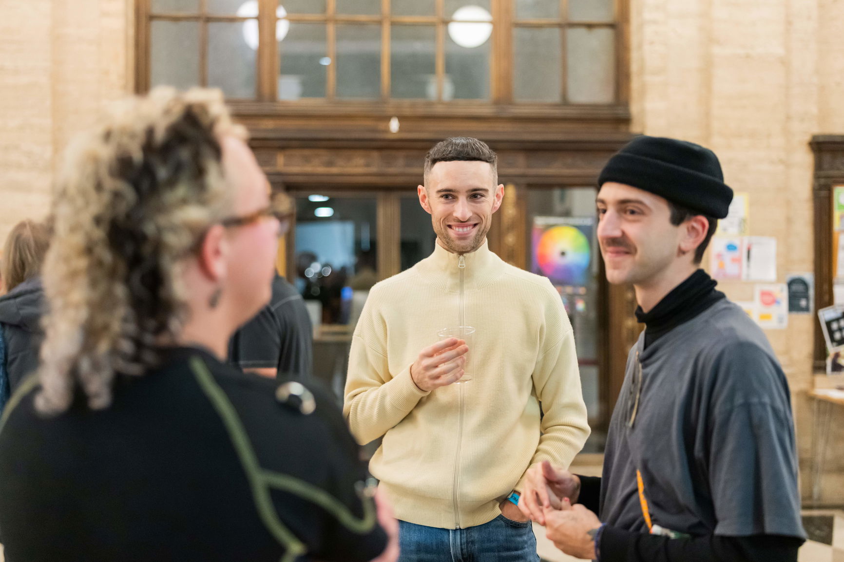 PNCA students stand in a circle chatting at a First Thursday event