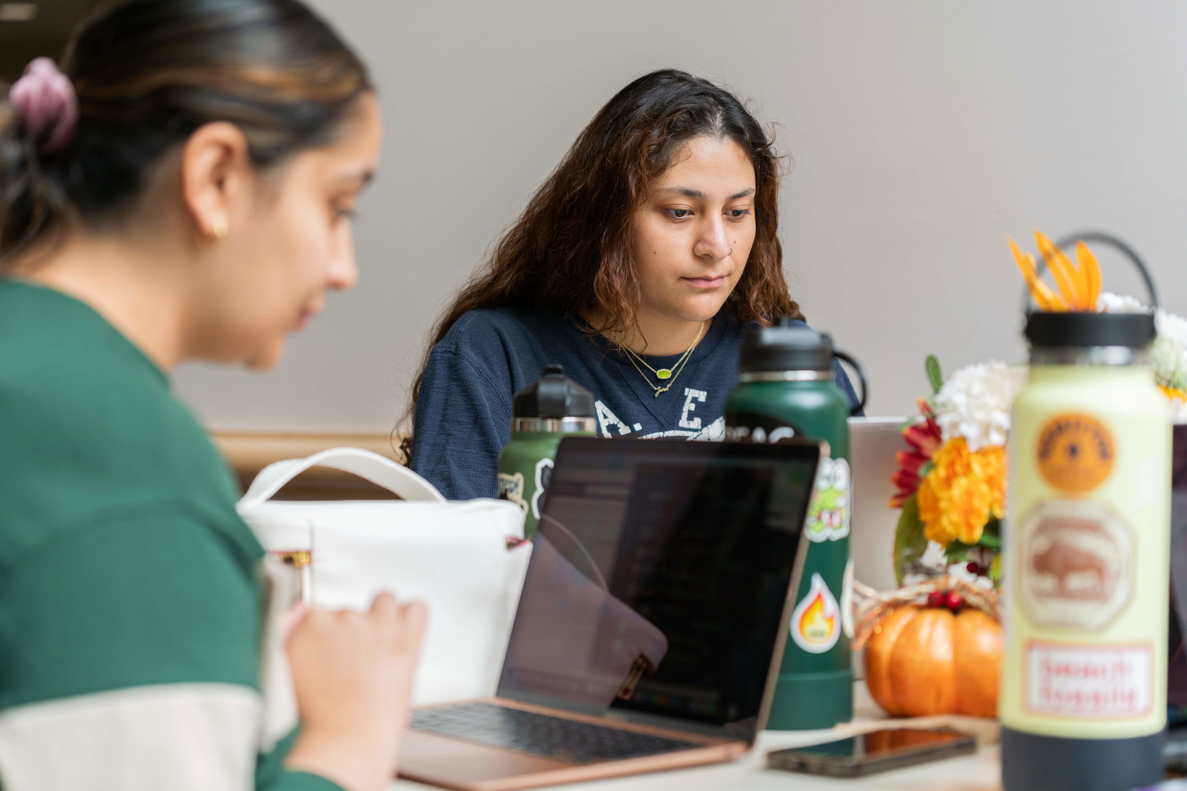 Two Willamette law students sit at a table at Rick's Cafe, working on laptops