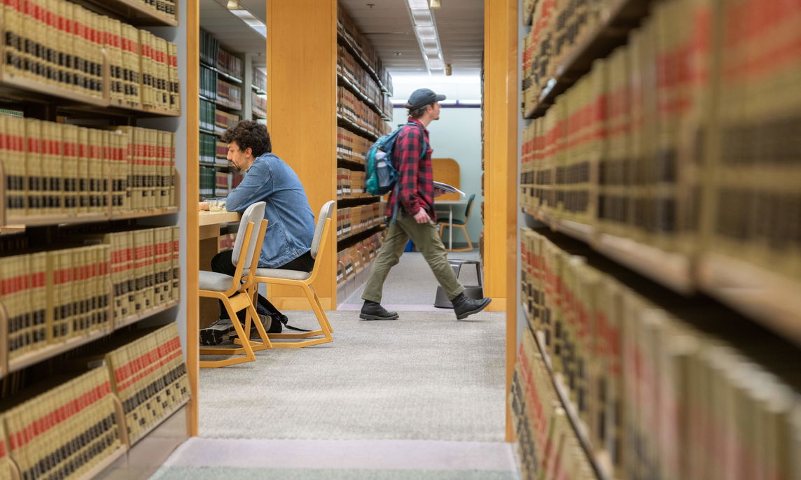 A student walking through the stacks of the law library