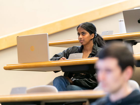 A Willamette law student sits in a lecture hall during class with her laptop in front of her