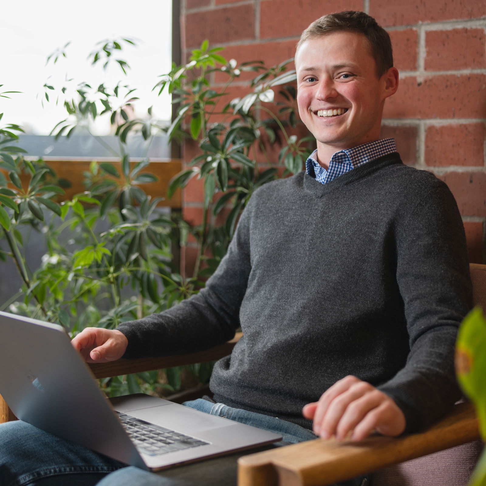 Riley Lankford sitting at desk smiling at camera head on