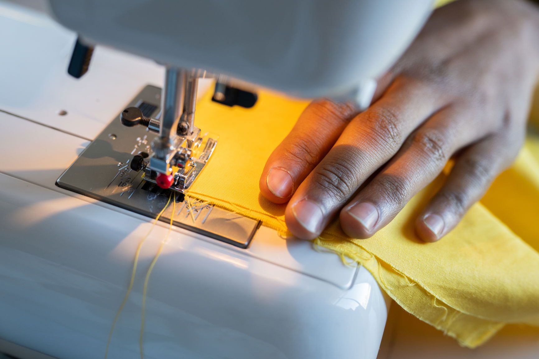 Close-up of fabric going through a sewing machine