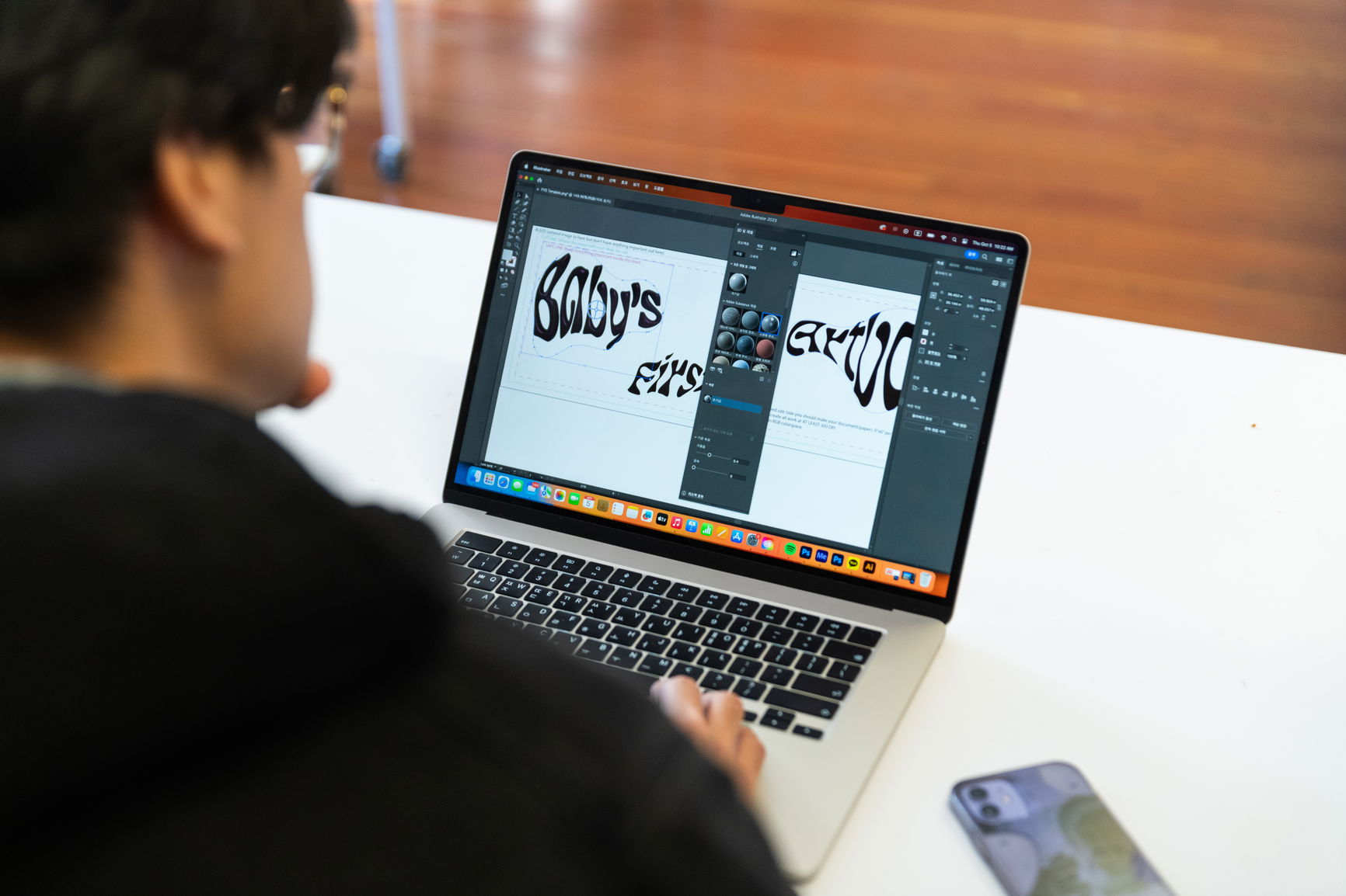 A student working on a graphic design project on a laptop