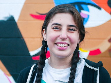 Person smiling on a colorful background. 