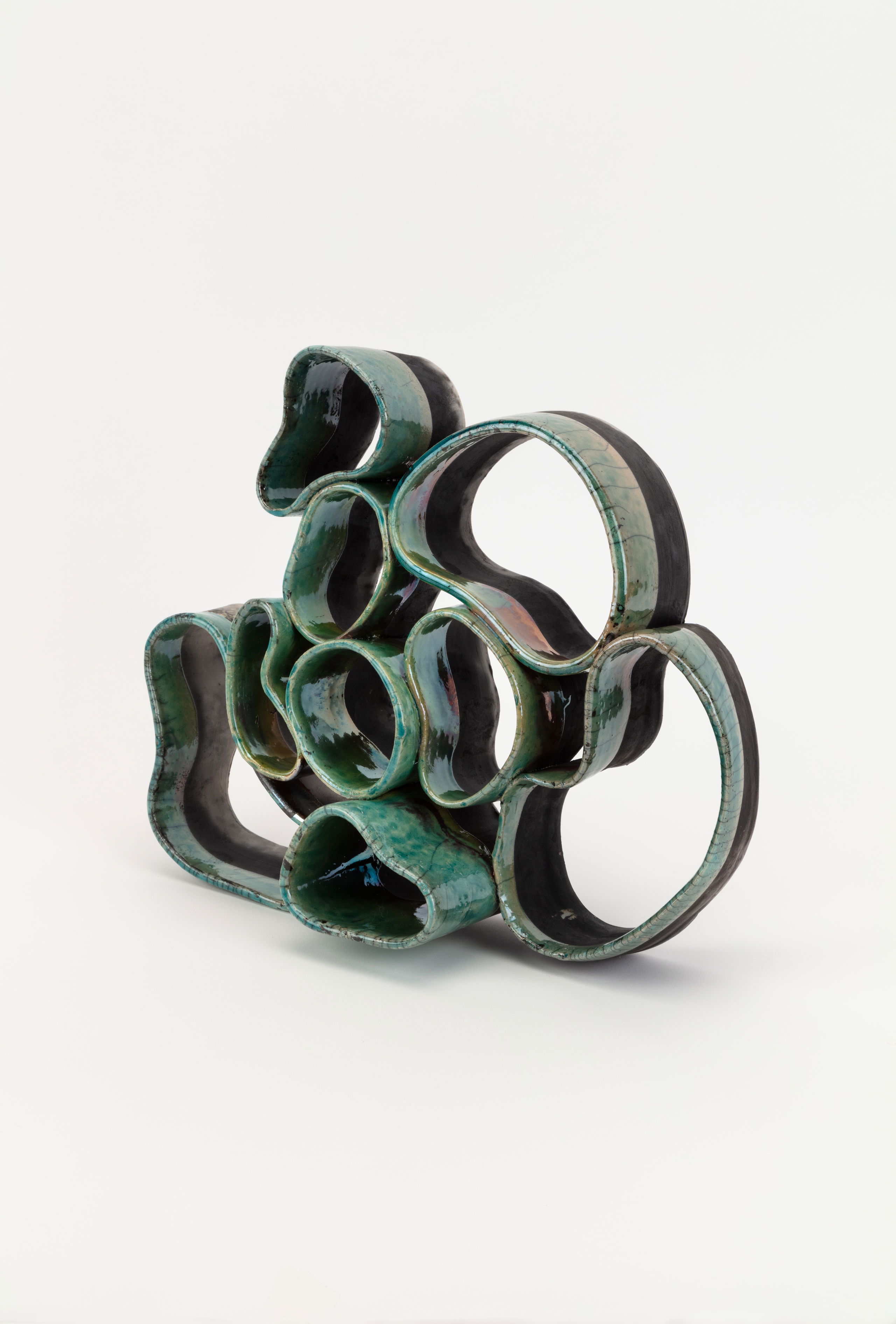 Green ceramic sculpture with round shapes. 